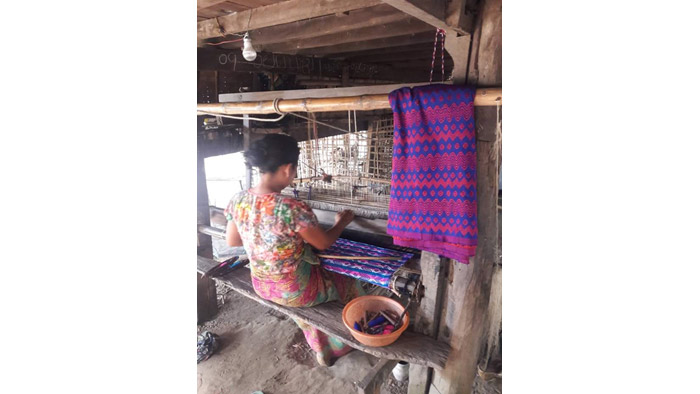 自宅の軒下の機織り機でロンジーを織る女性（ミャンマー・ラカイン州）