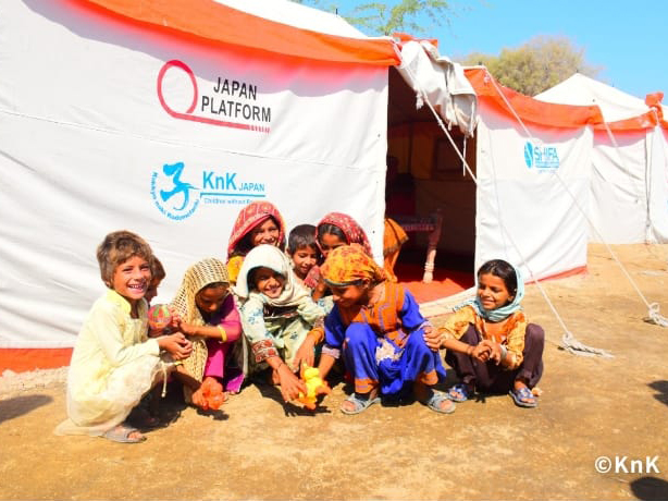 配布されたテントの前で笑顔を見せる子どもたち ©KnK(パキスタン水害)