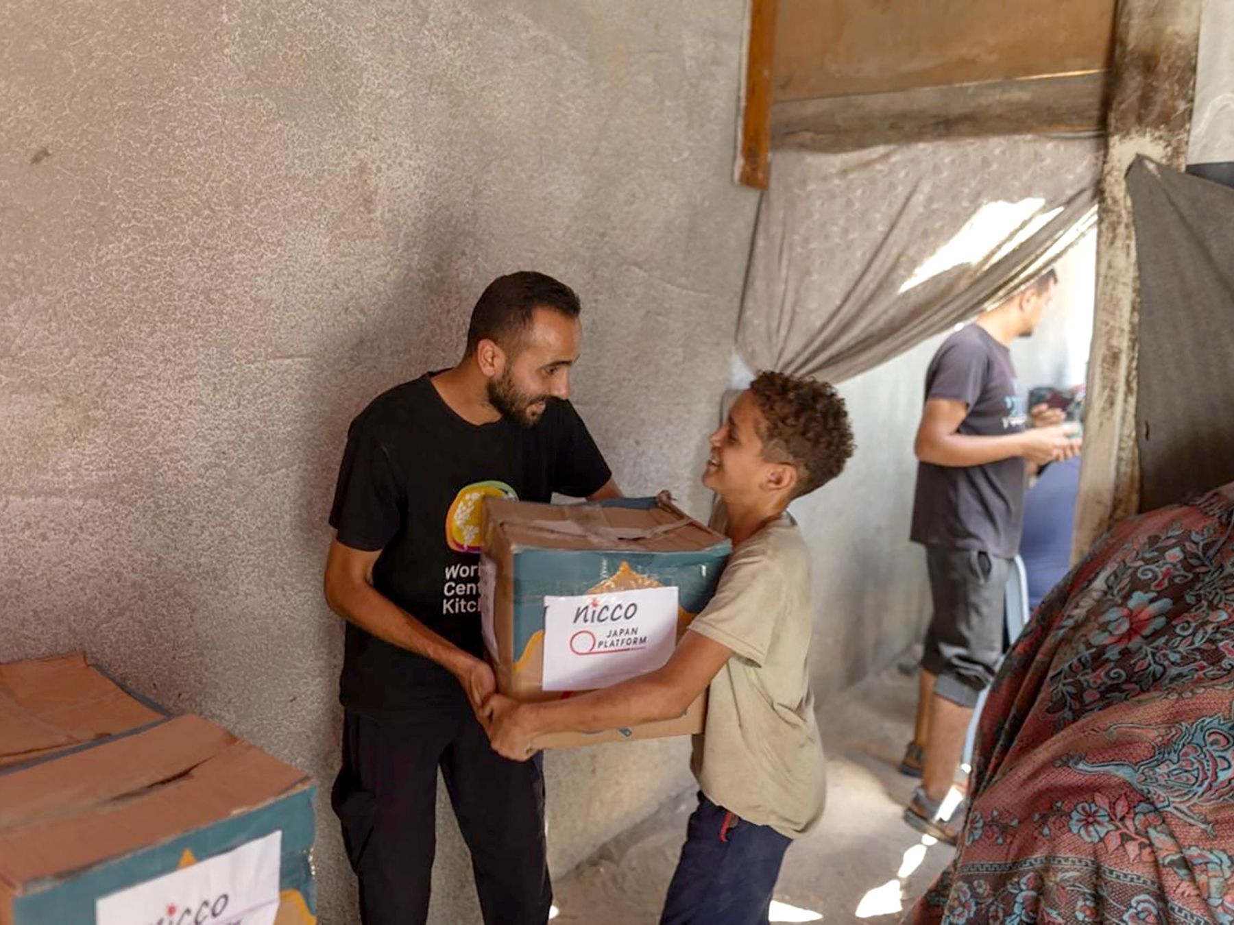 食料を配布する現地スタッフと、受け取るガザの人々 ©WCK