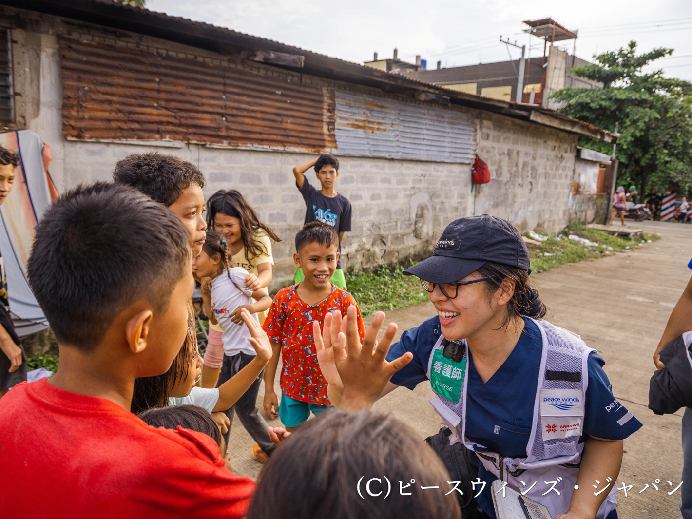 集落の子どもたちと笑顔でコミュニケーションをとる看護師🄫ピースウィンズ・ジャパン(フィリピンセブ島)