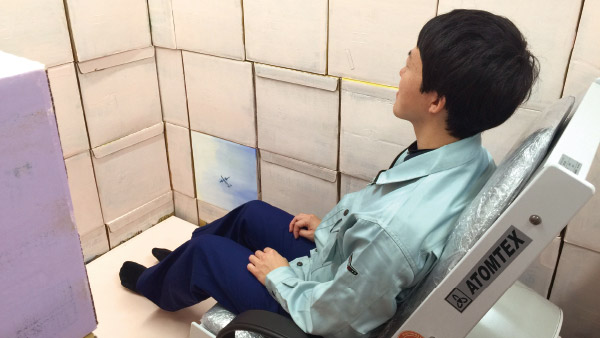 ホールボディカウンターに座り、人体の放射線量を測定する様子 ©たらちね