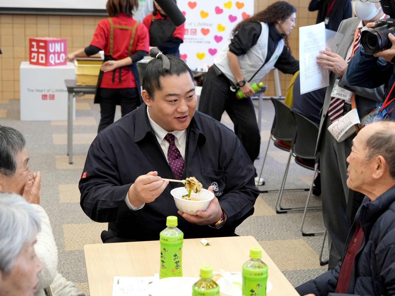 来場者と談笑しながらちゃんこ鍋を食べる北陣親方／石川県能美市／2025.12.06 &copy;ユニクロ