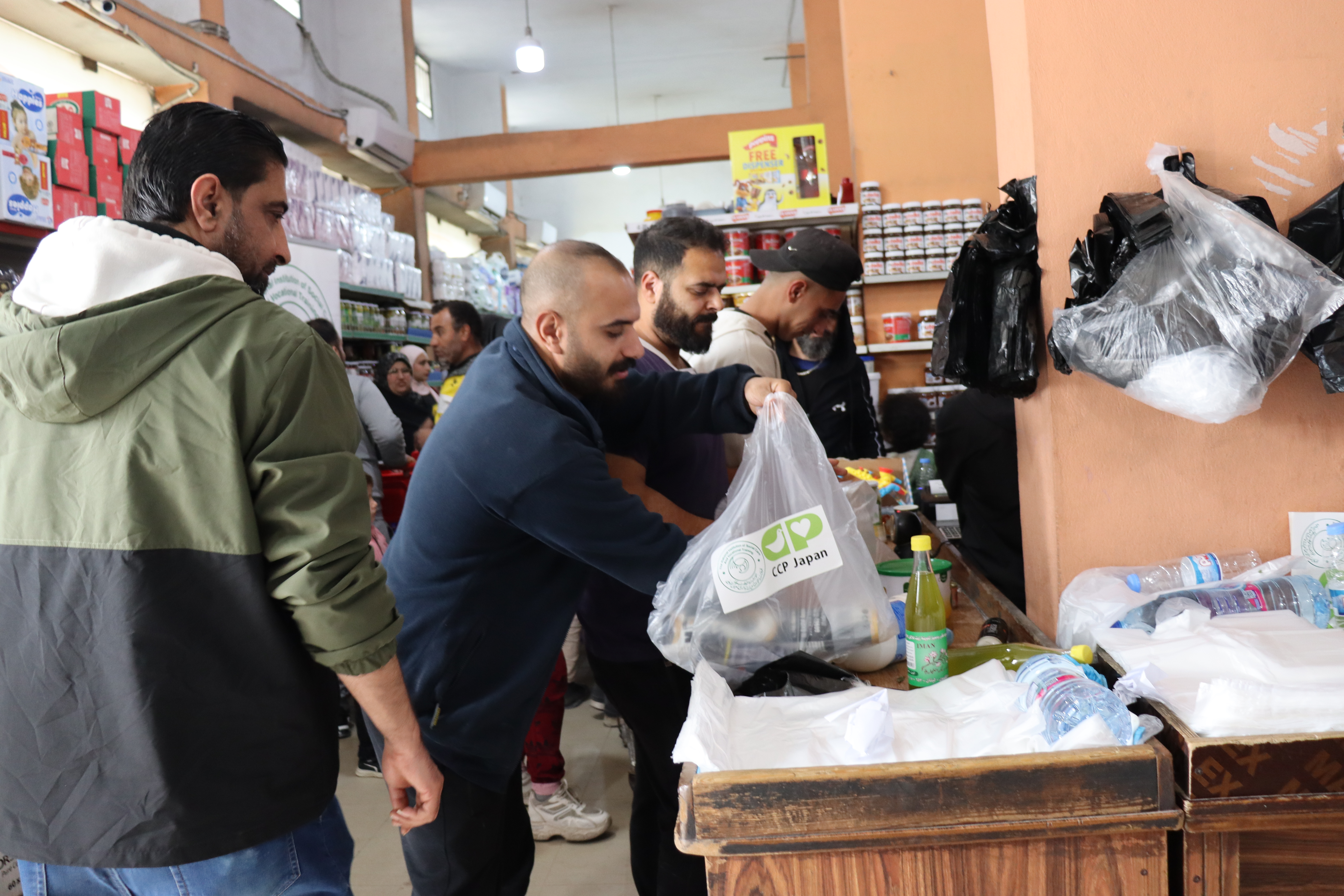 引換券で購入した食料品を袋詰めする人々／北レバノン県／2026.04.05／ &copy;CCP