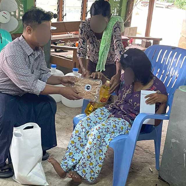 提携団体職員から支援物資を受け取るテインギさん(右)