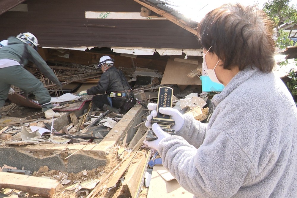 崩壊した建物から重機を使って大切なものを取り出す支援