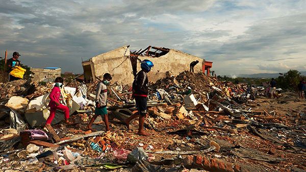 発災後、限られた足場を歩く人々／10月7日／パル市、インドネシア ©Lewis Inman/Arete Stories/DEC