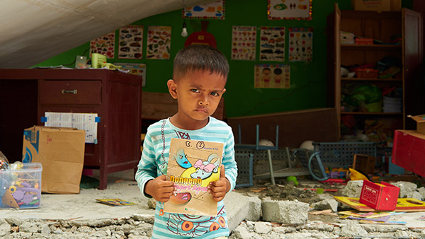 被災した小学校の前に立つ子ども／10月7日／シギ県、インドネシア ©Lewis Inman/Arete Stories/DEC