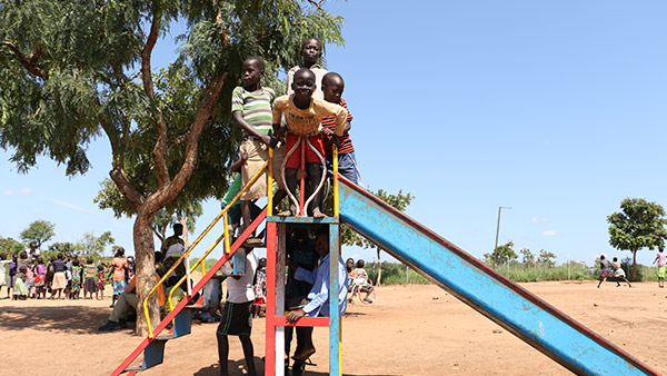 子どもひろばの滑り台にのぼる子どもたち ©World Vision