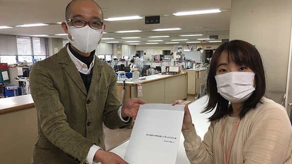 Mr. Mizuno (left) presenting booklet to the General Office for Reconstruction of Kumamoto City ©Studylife Kumamoto