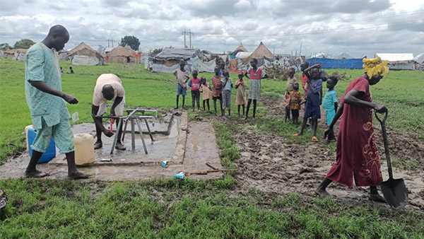 メルートIDPキャンプの給水所で壊れた蛇口の交換を行う水管理委員会と清掃する避難民の人々 ©ピースウィンズ